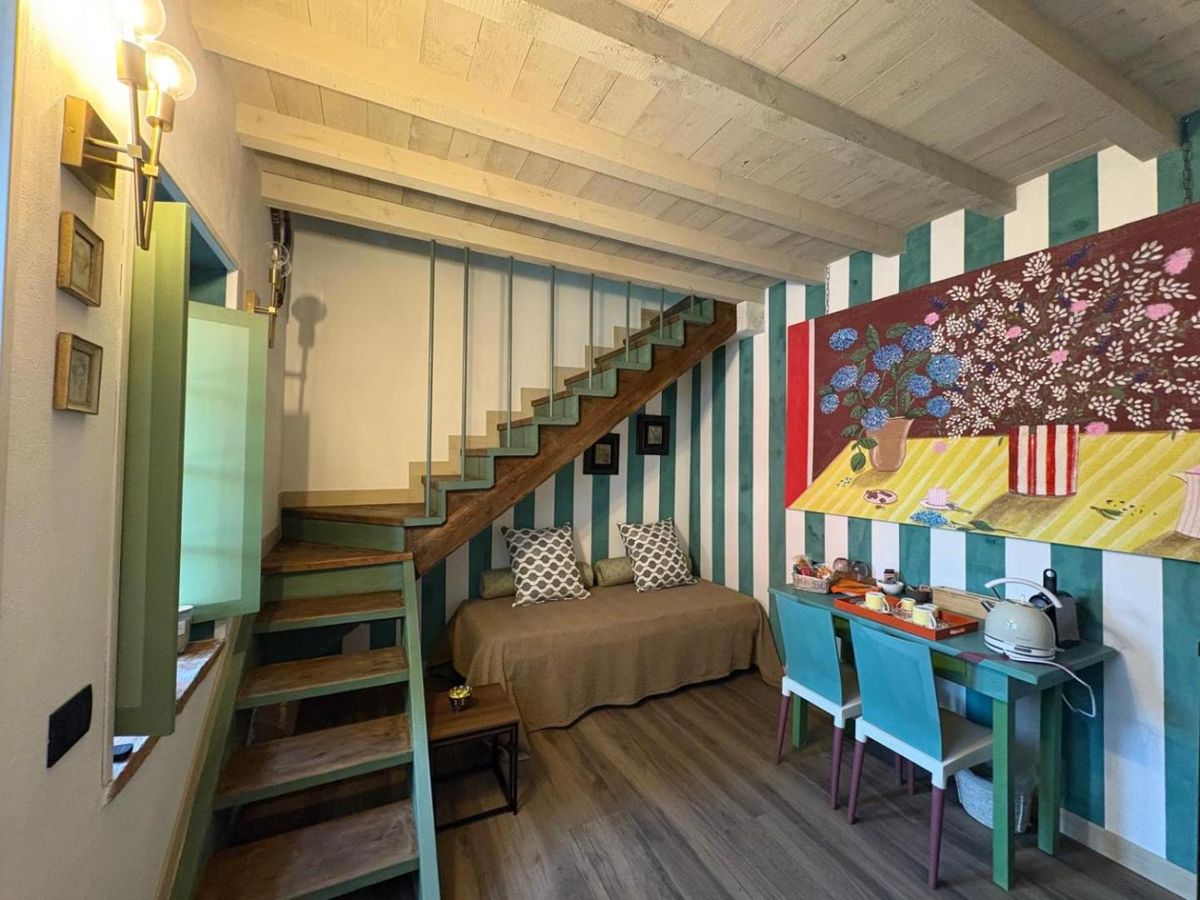 La Suite di Villa La Canonica su due livelli con righe verde salvia e scala in legno